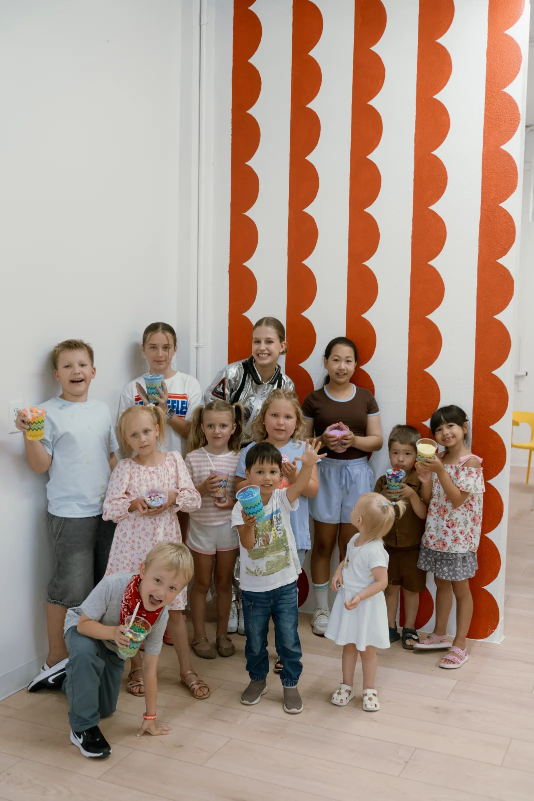 A birthday group gathered at the orange scalloped wall at Lemur Lulu venue near Seattle